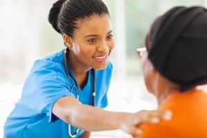 Caring African-American nurse with a patient