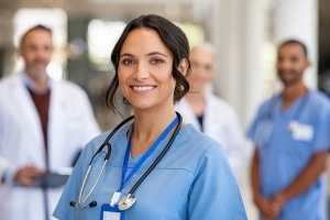 Smiling nurse with a team behind her