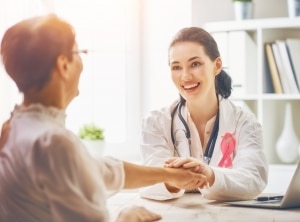 Healthcare professional holding the hand of an oncology patient